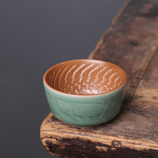 Longquan Plum-Green teacup featuring a traditional Dragon-Fish design, symbolizing success and transformation.