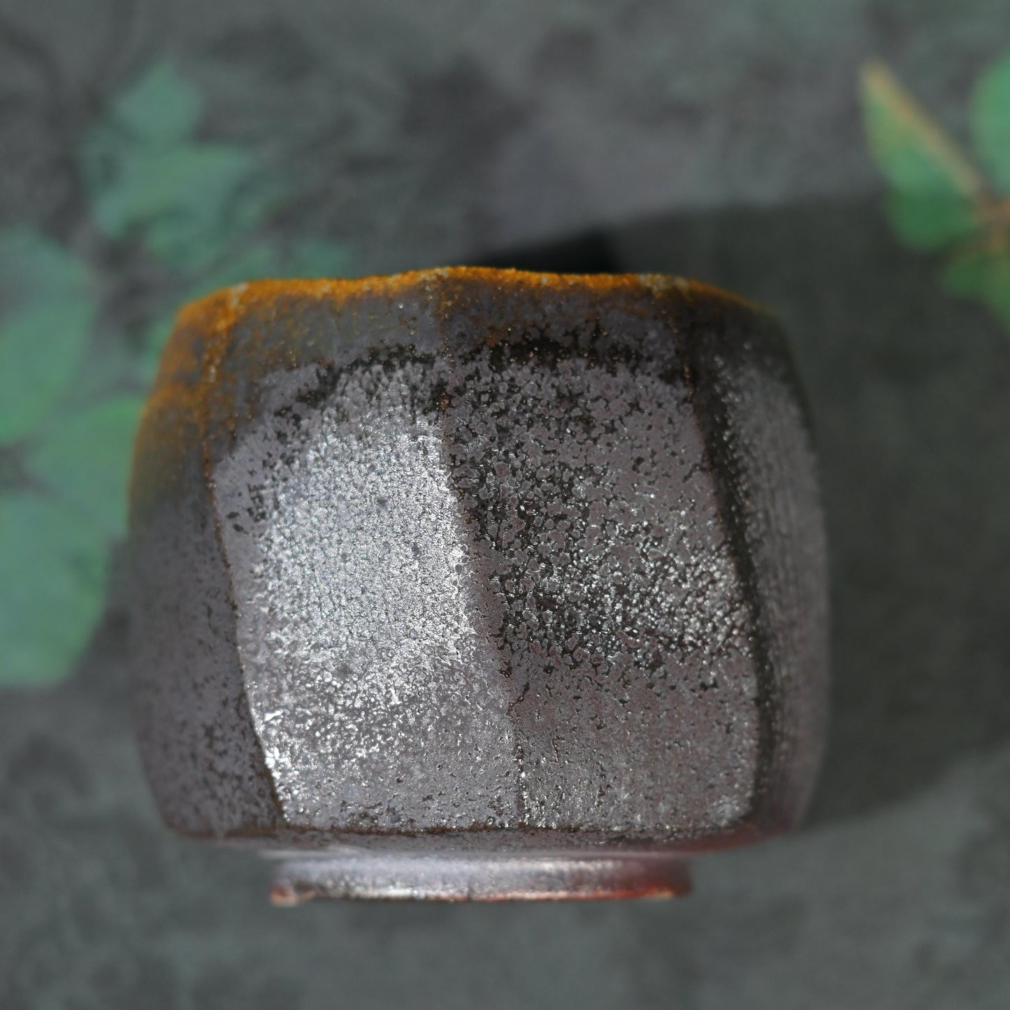 Singular piece wood-fired teacup against a dark, rustic background for tea connoisseurs.