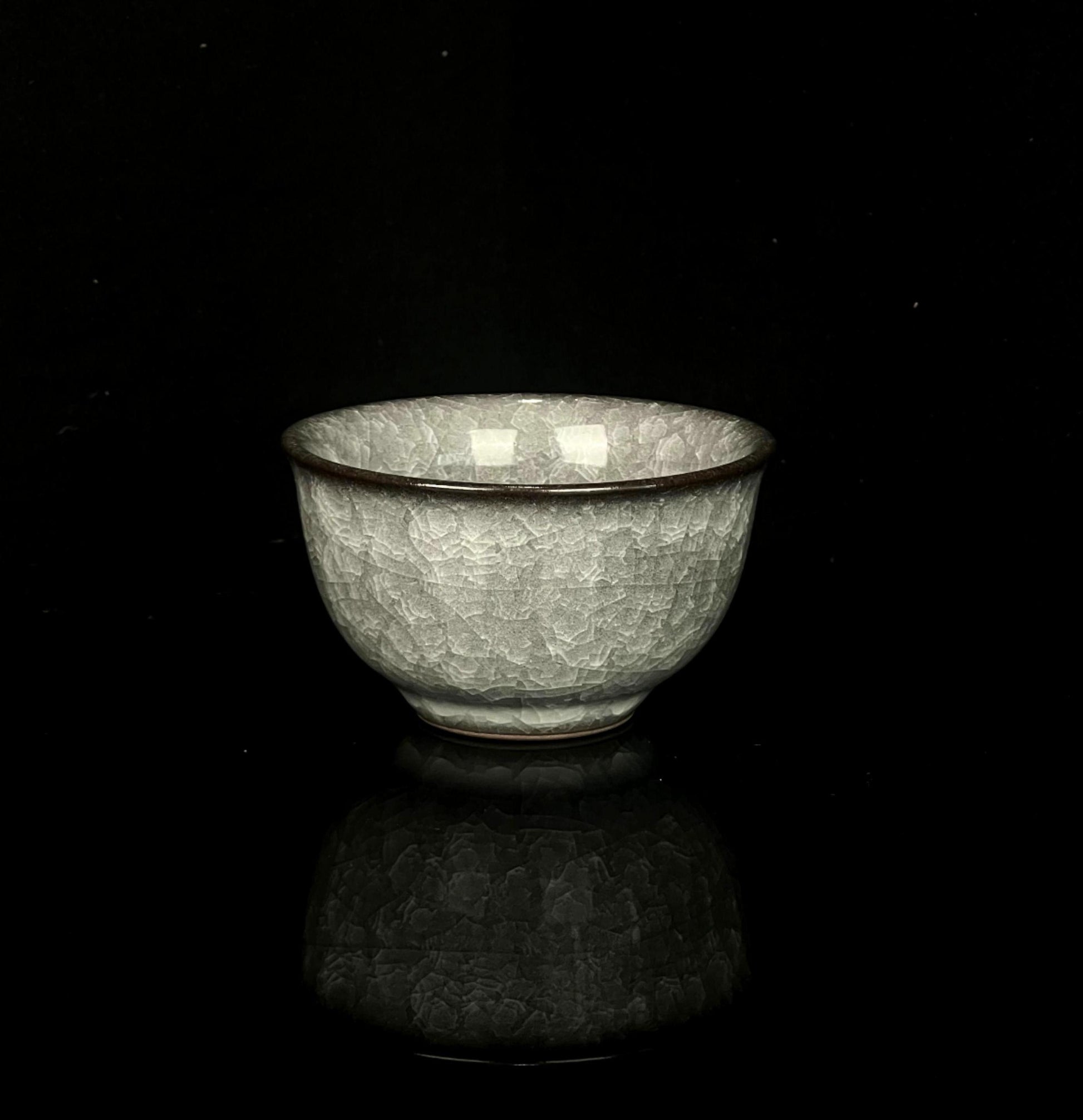 Ancient style Longquan celadon cup featuring ice crackle glaze and ya shou design for comfortable handling