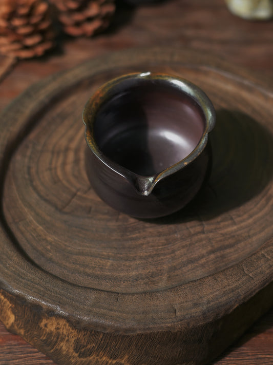 Close-up view of the deep obsidian finish and mineral flecks of a wood-fired Cha Hai.