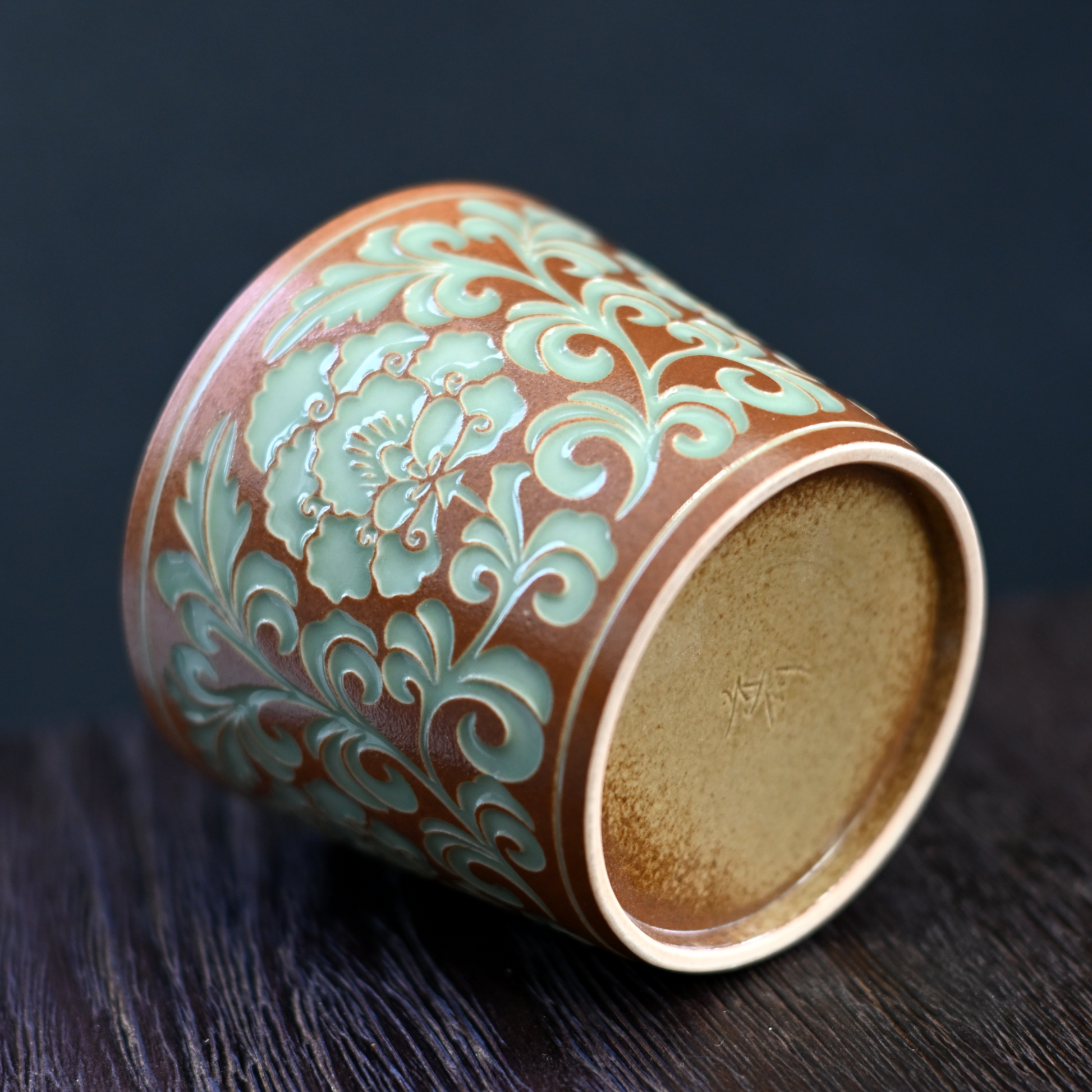 Organic plant ash glaze celadon cup with 3D peony carving, made in Longquan using ancient techniques with 260ml multi-drink capacity.