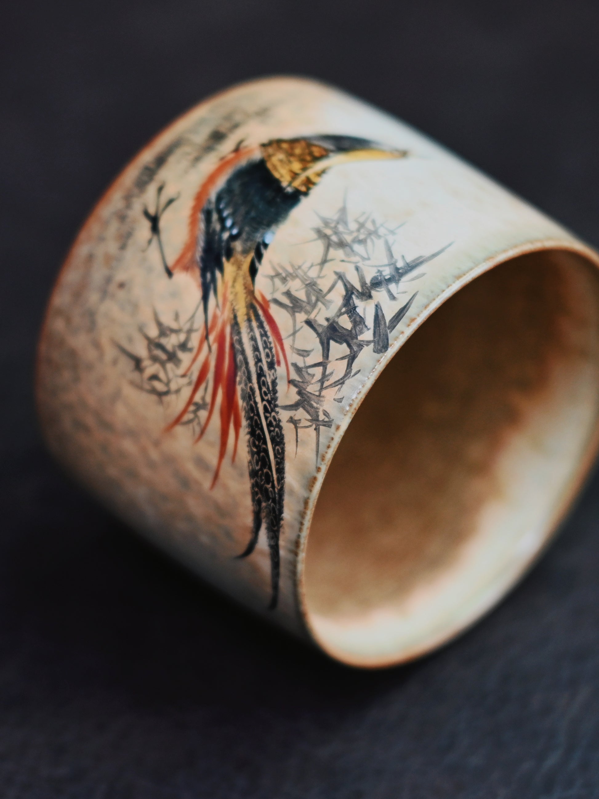 Hand-formed cup with traditional Chinese nature painting, bridging heritage and modern use.