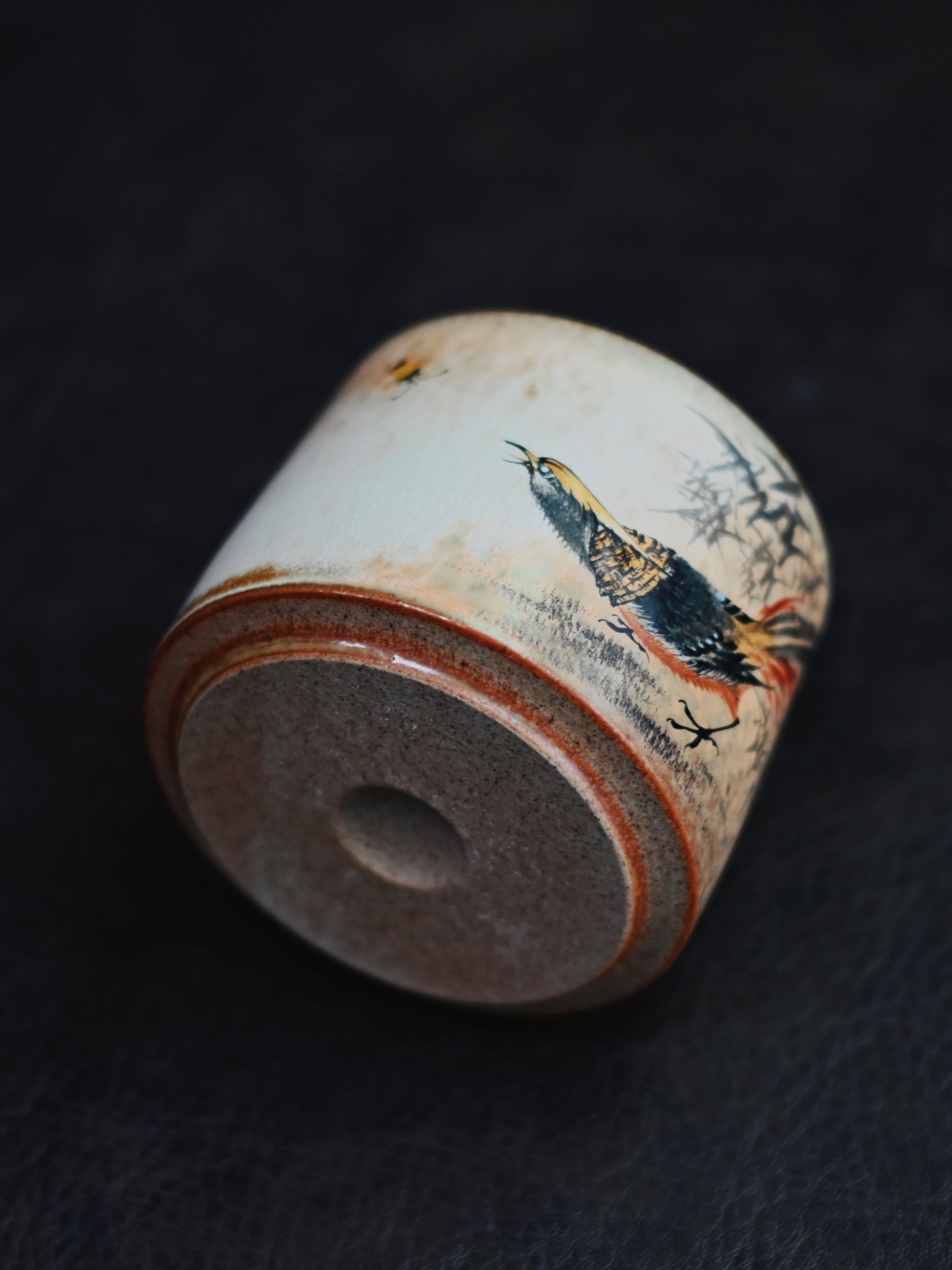 Tactile hand-built teacup featuring raised brushstrokes of floral and avian designs, combining Jingdezhen's clay artistry with painting tradition.