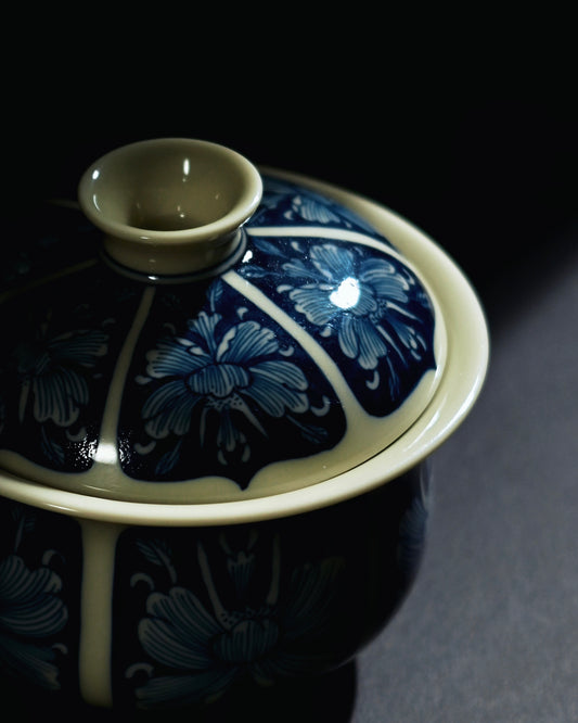 Hand-painted peony tea bowl where cobalt forms continuous background and flowers emerge in white