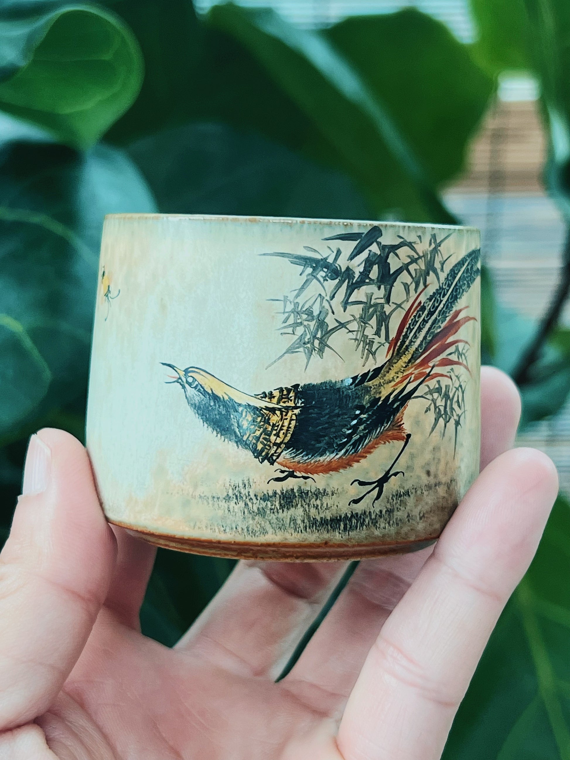 Artisanal Jingdezhen porcelain cup, hand-shaped on the wheel and decorated with classic Chinese nature motifs using mineral pigments and antique styling.