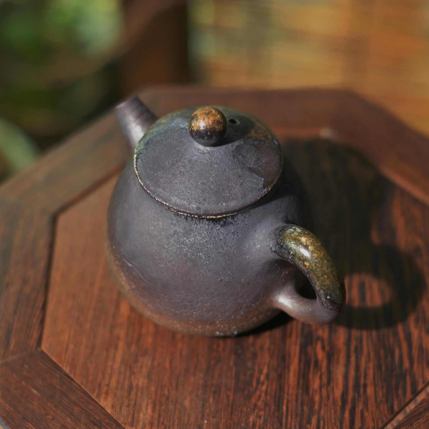 Hand-thrown stoneware teapot showing natural metallic luster and kiln-fired characteristics.
