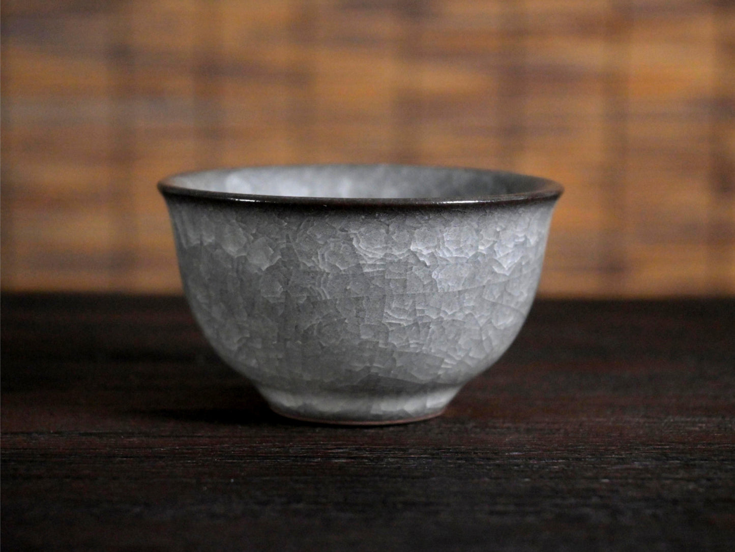 Handcrafted Longquan celadon tea cup featuring classic ice crackle patterning and comfortable weighted bottom