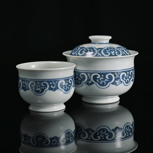 Jingdezhen Imperial blue-and-white gaiwan set with hand-painted ruyi cloud motifs, symbolizing auspiciousness and crafted from high-kaolin clay for Qing Dynasty-style tea ceremonies.