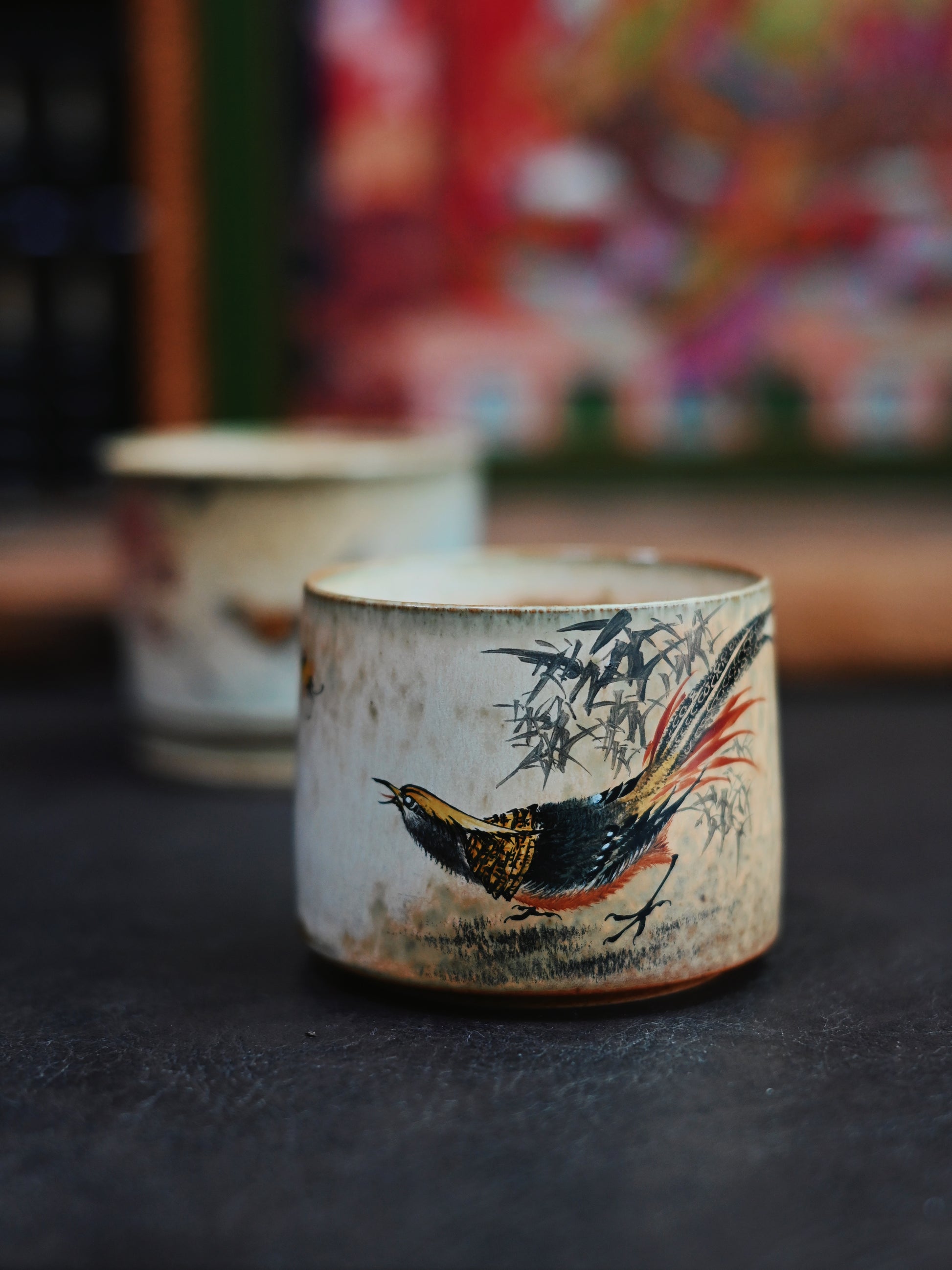 Vintage-style teacup showcasing Jingdezhen's ceramic legacy through hand-sculpted form and traditional Chinese bird-and-flower painting techniques.
