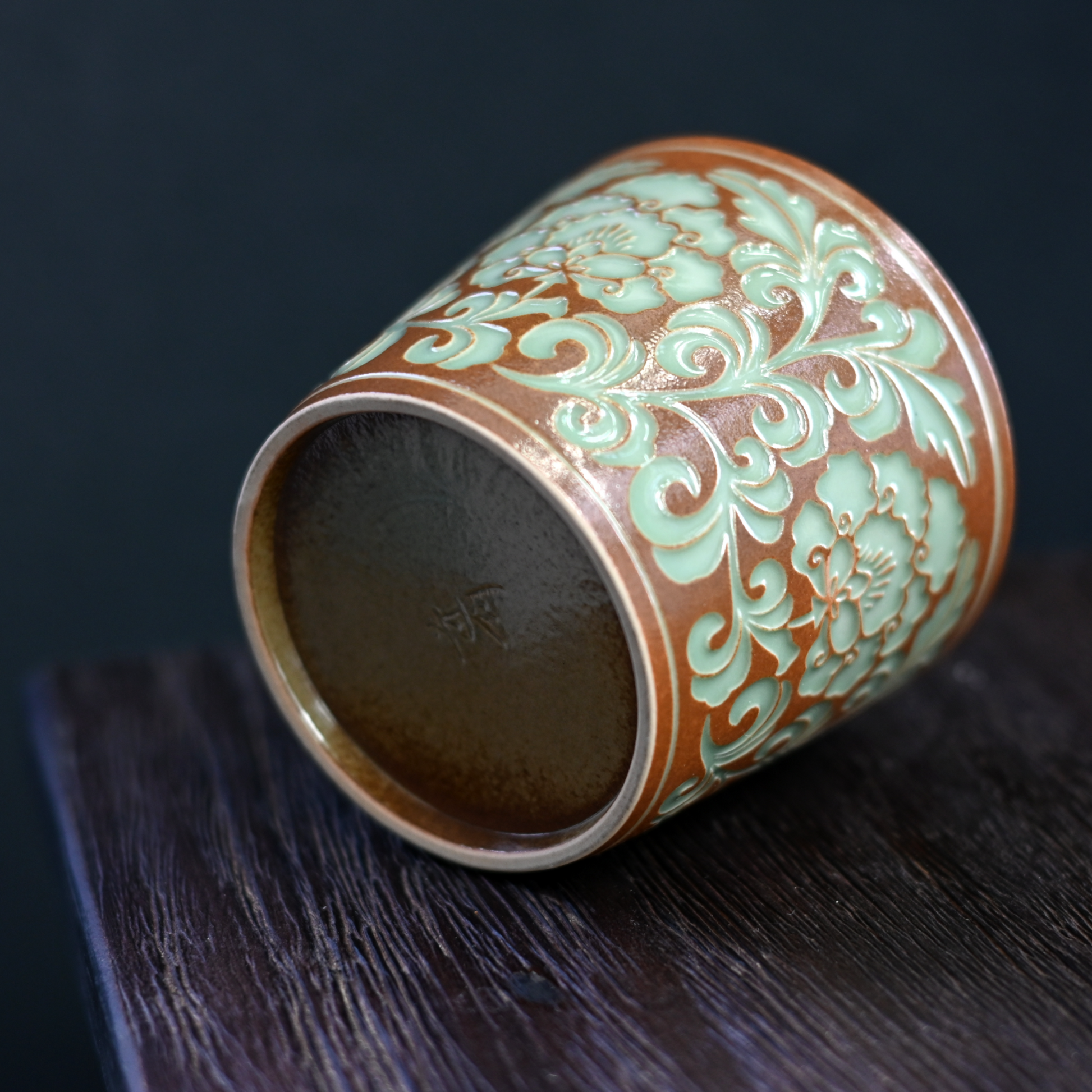 Hand-carved peony vines enhance grip on this Longquan celadon mug, featuring plant ash glaze and 260ml capacity for hot/cold beverages.