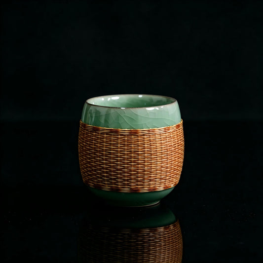 Bamboo‑joint shape Longquan Ge‑Yao celadon teacup, hand‑woven bamboo wrap, studio photo on pure black background with reflection