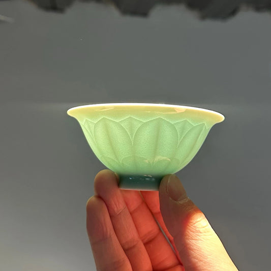 Backlit shot showing the incredible translucency of the thin porcelain Longquan Celadon lotus tea cup.