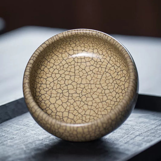 Handcrafted Ge Kiln style tea cup featuring intricate gold thread and iron wire crackle glaze pattern.