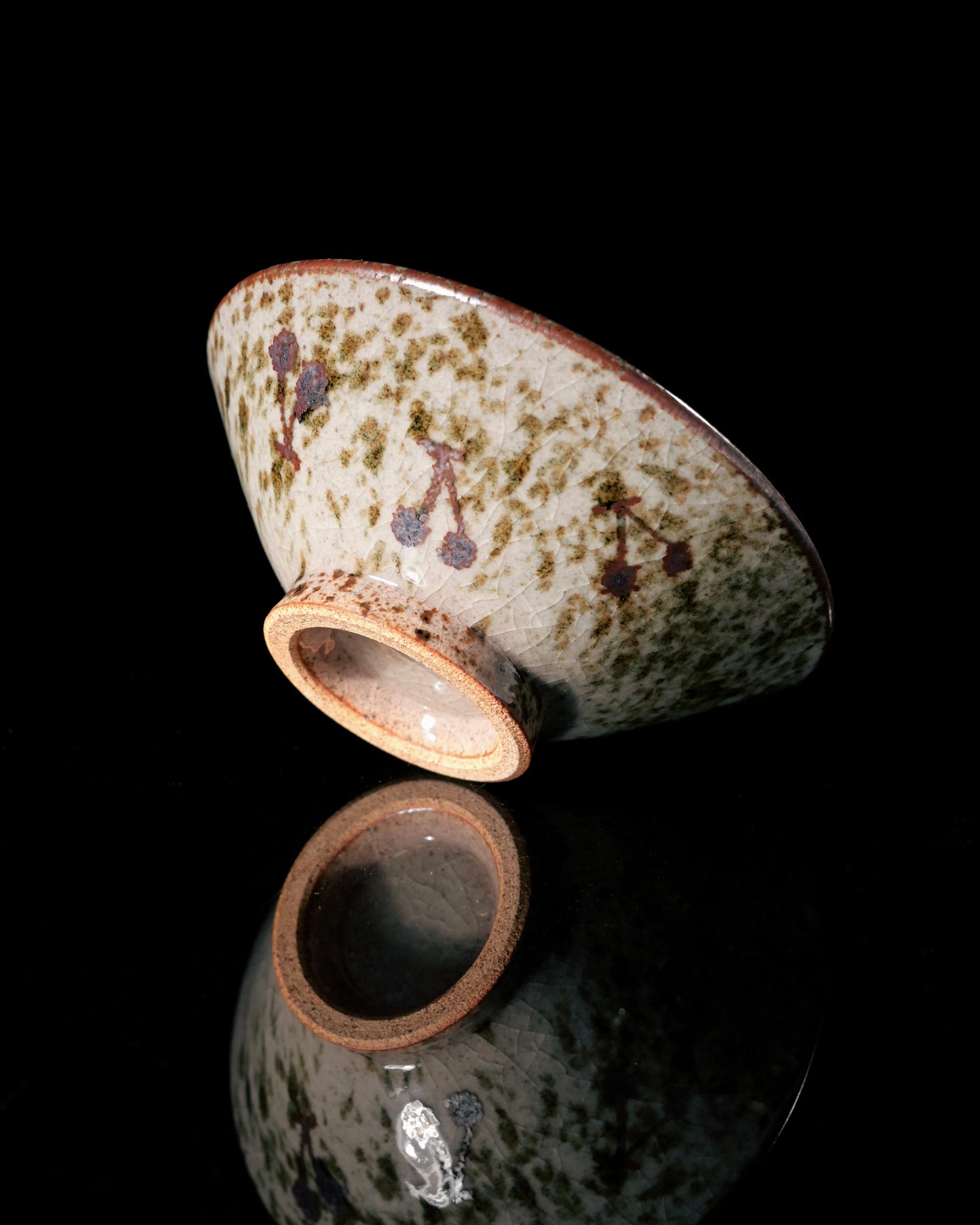 Handcrafted wood-kiln tea cup featuring naturally formed ash glaze and irregular iron spots from firing process