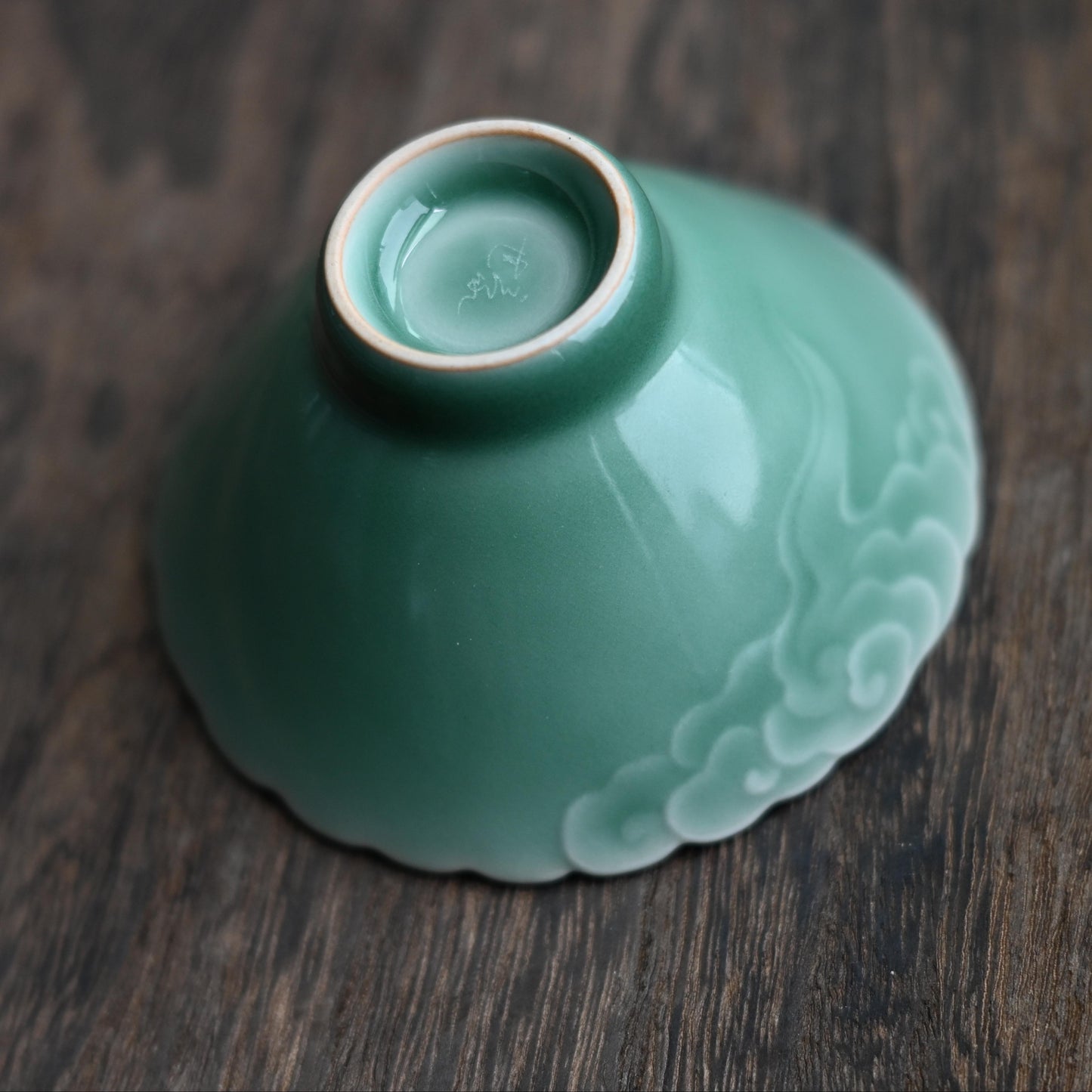 3D cloud design tea bowl with plum green celadon finish, creating tactile and visual interest for tea enjoyment