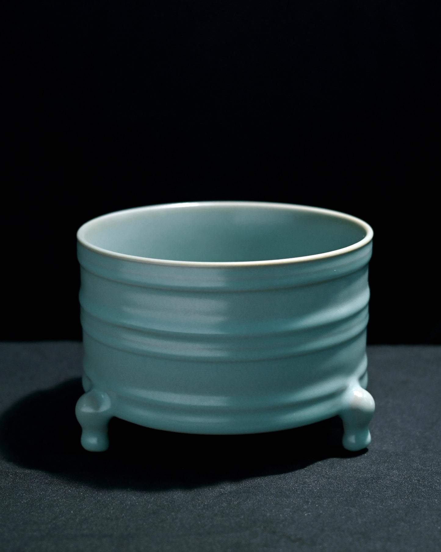 Ru ware Zun showing incense ash clay body through thin glaze areas at raised patterns