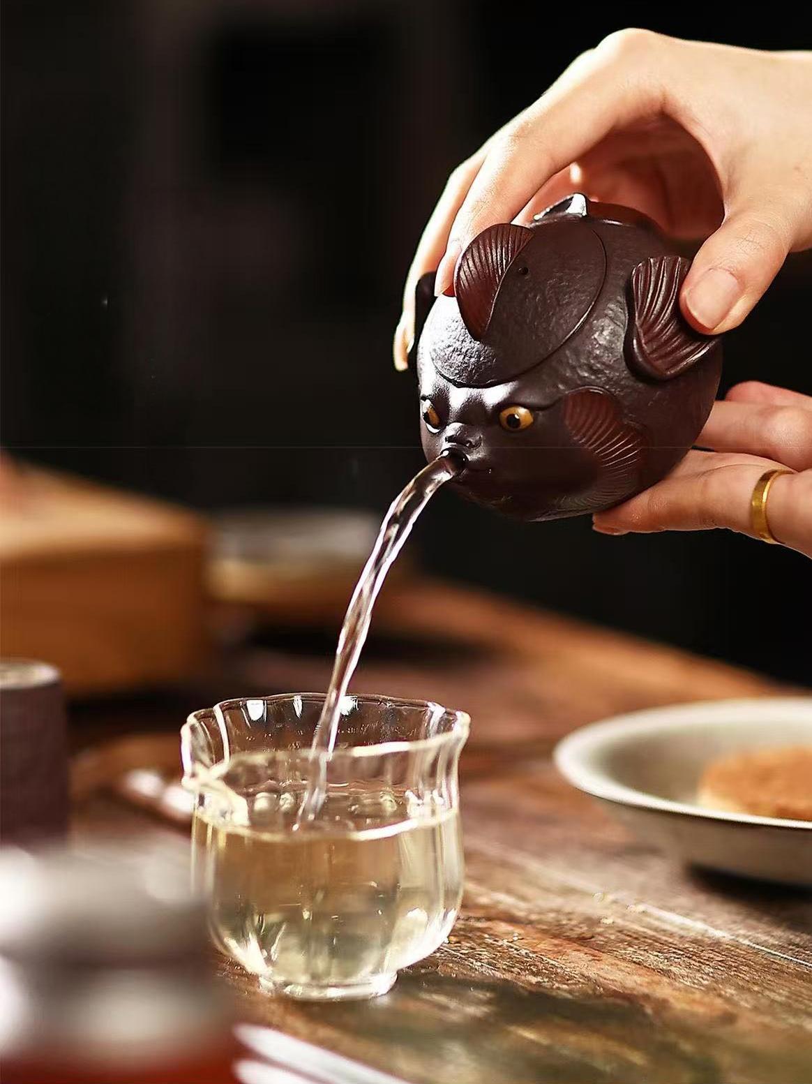 Aged Yixing zini clay pufferfish teapot with removable stainless steel filter, showcasing traditional zisha craftsmanship in whimsical design