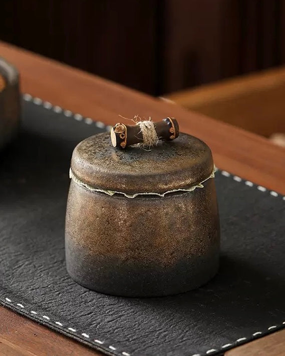 Artistic Chinese tea caddy made of fine stoneware with a golden relief design.
