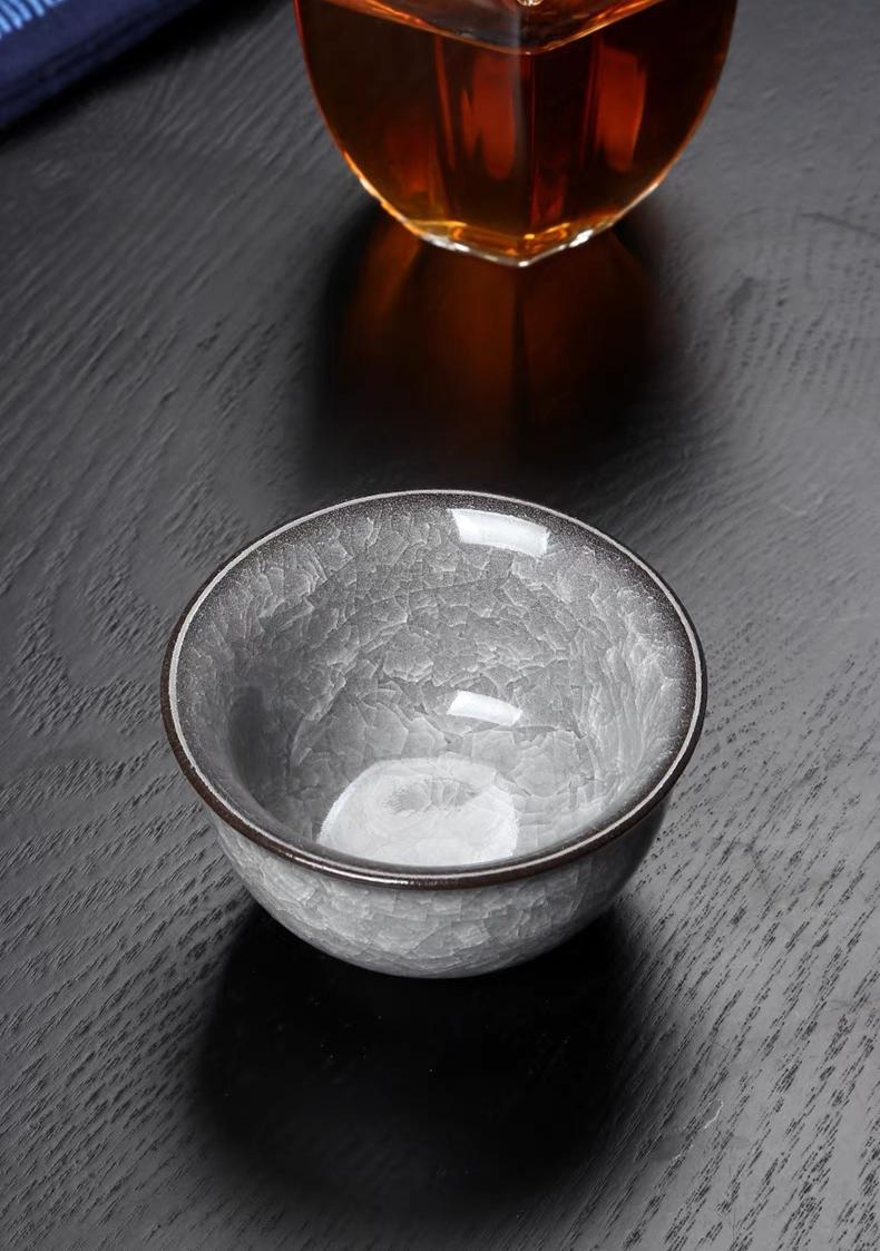 Traditional Chinese press-hand tea cup in Longquan celadon, featuring ice crackle patterning and weighted base for stability