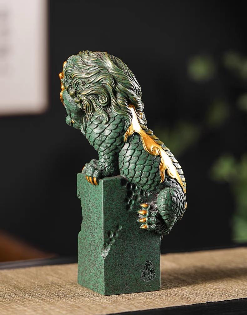 Traditional Chinese tea pet featuring winding dragon design with gold accents on green stone