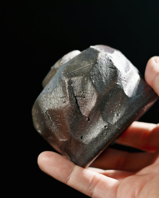 Unglazed stoneware surface revealing natural iron flecks and embedded sand particles