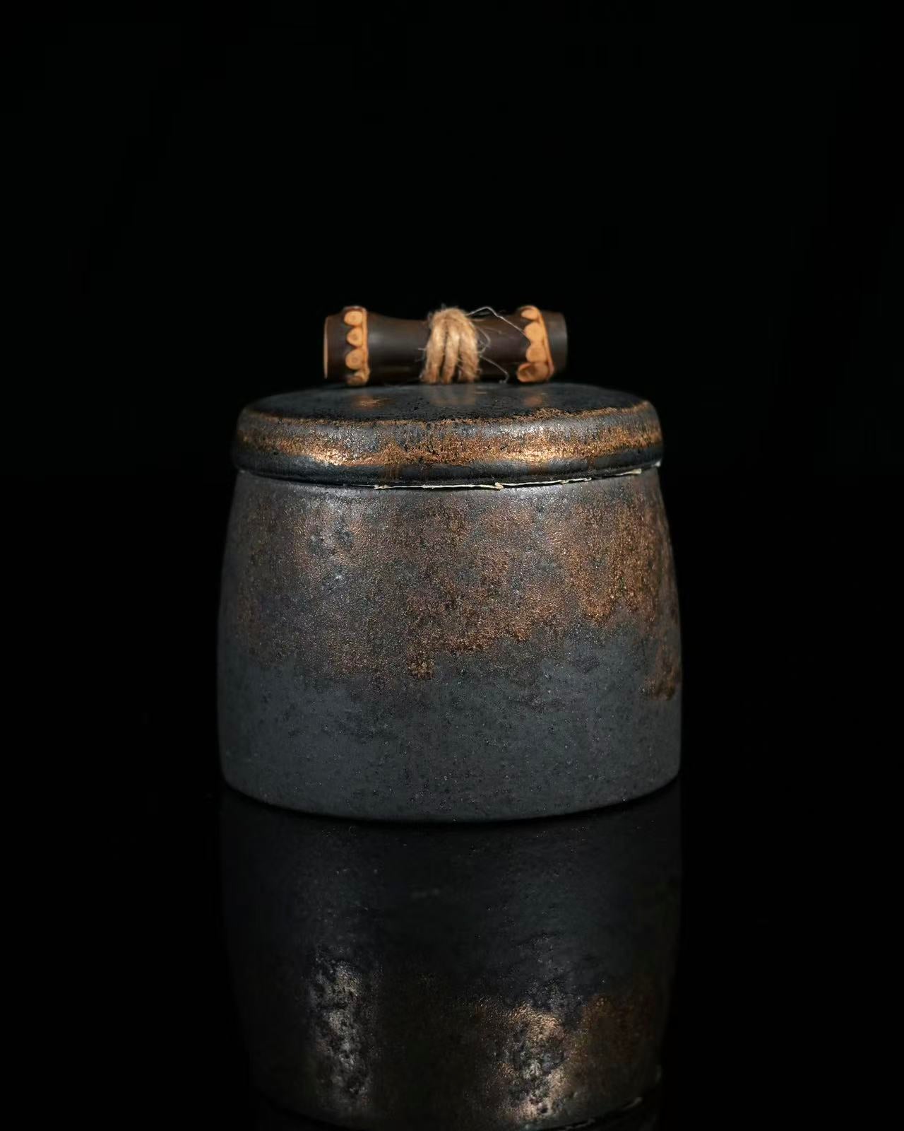 Handcrafted small stoneware tea caddy with vintage gilded patterns and charm.