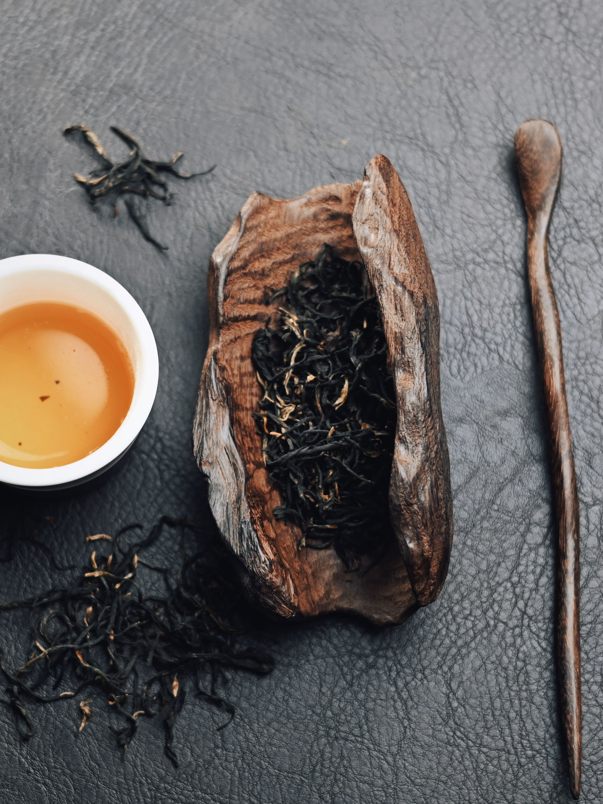 Rustic tea ceremony scoop carved from solid iron wood, featuring natural wood grain and carbon finish