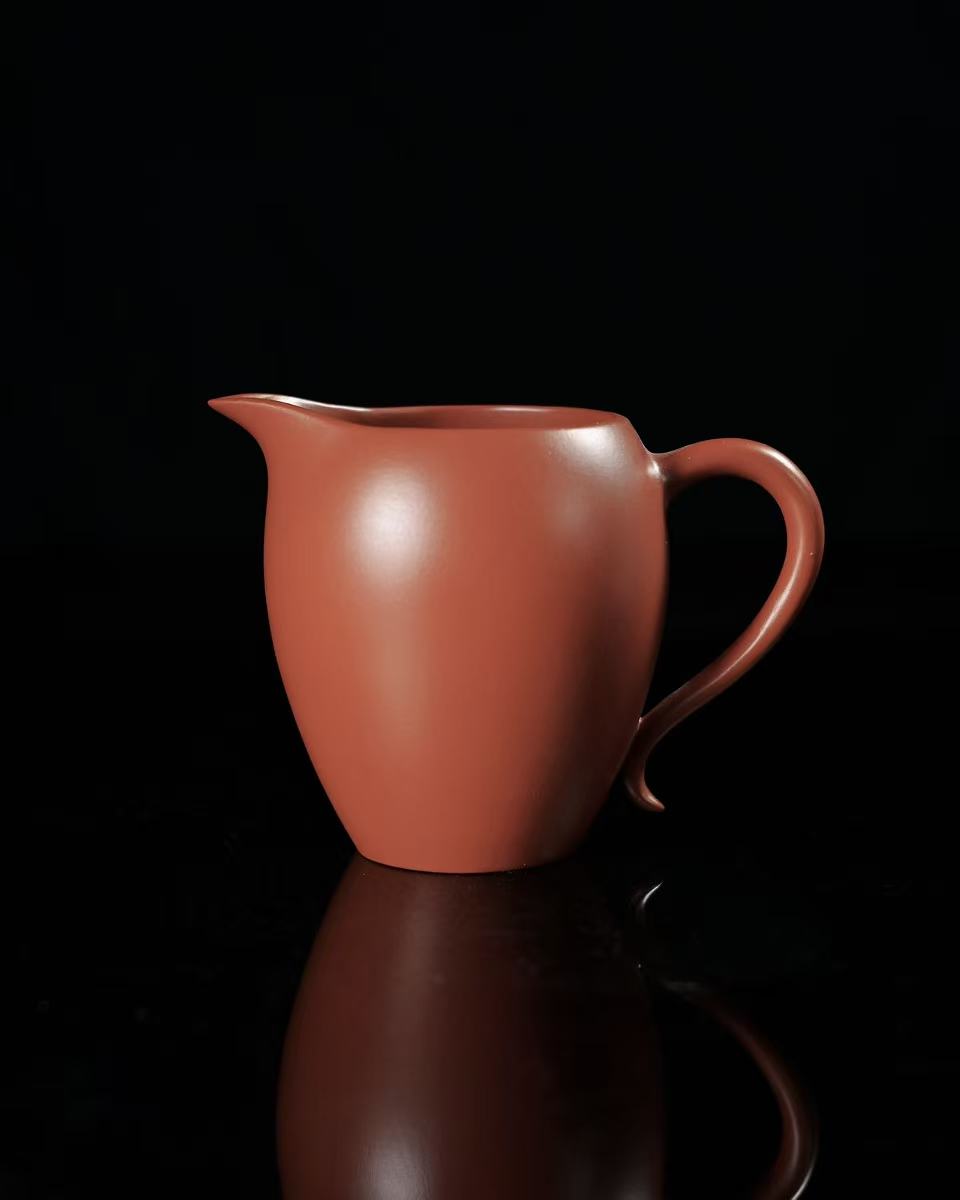 Demonstrating tea pouring from fairness cup to ensure even distribution of flavor and temperature