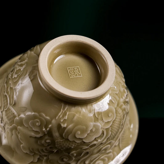 Side profile of the unique yellow glaze Longquan Celadon tea cup with textured dragon scales design and flared rim.