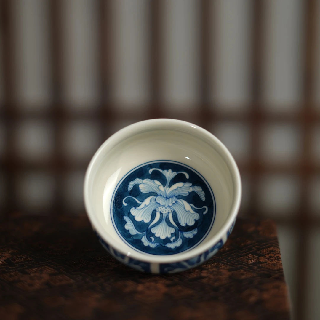 Interior view of a blue-and-white teacup showing a central peony flower medallion.