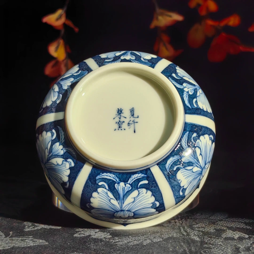 Hand-painted cobalt blue pigments on a fine white porcelain peony-themed cup.