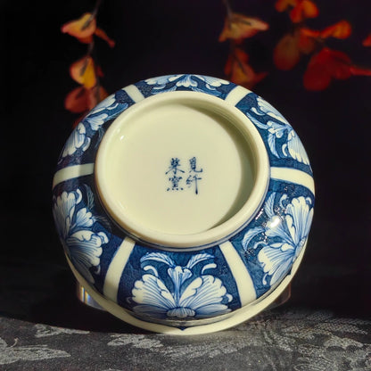 Hand-painted cobalt blue pigments on a fine white porcelain peony-themed cup.