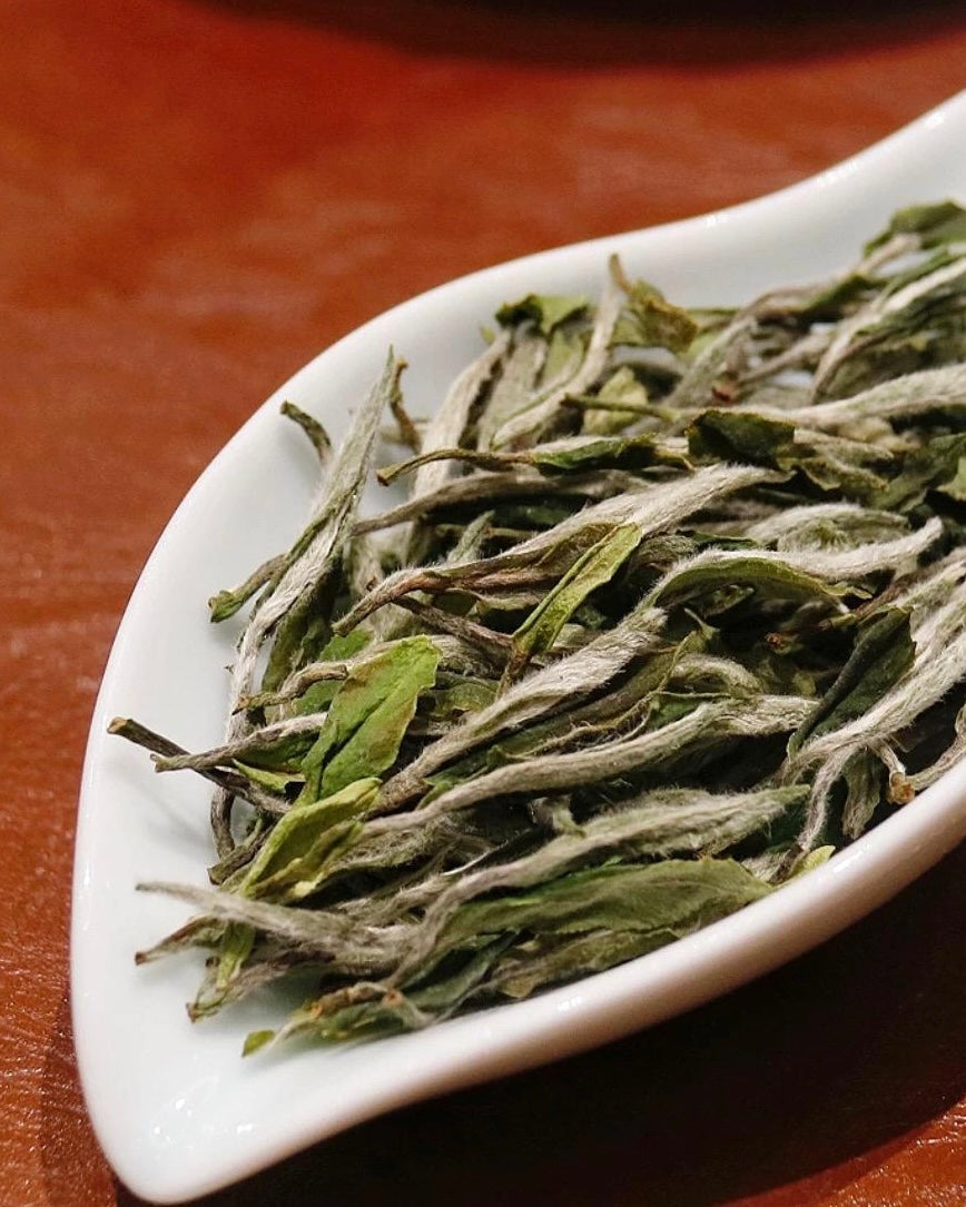 2025 Supreme White Peony dry tea leaves showing silvery buds and emerald green leaves with fine pekoe