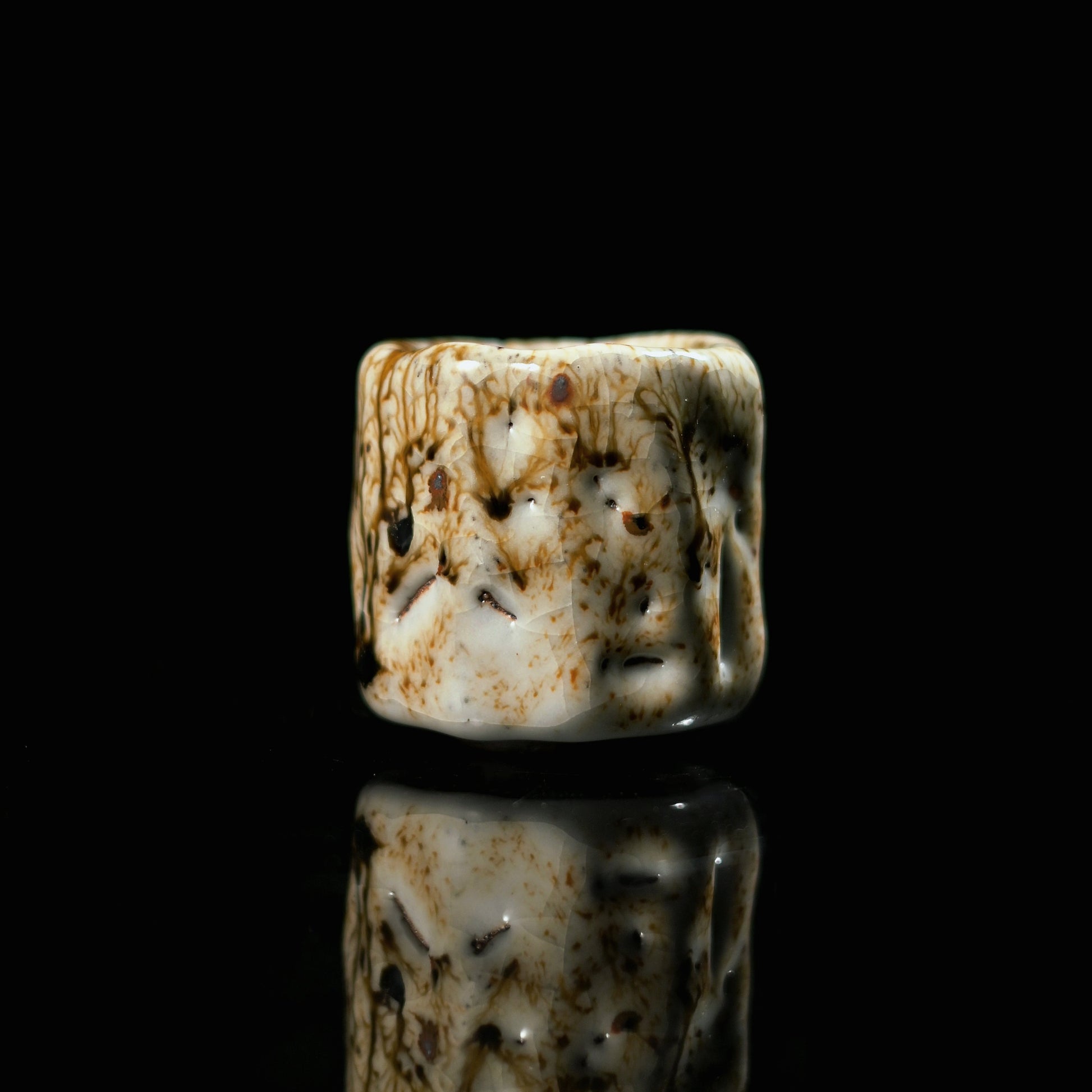 Unique piece Wabi-Sabi Shino teacup named "Ashes Bloom" with a milky white glaze and dark iron spots.