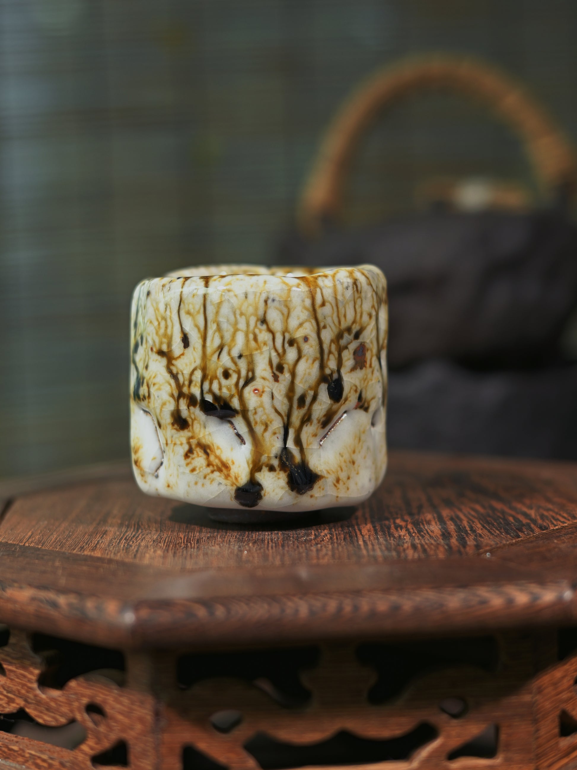 Close-up of the "Ashes Bloom" effect on a handmade Shino tea cup, showcasing natural mineral textures.