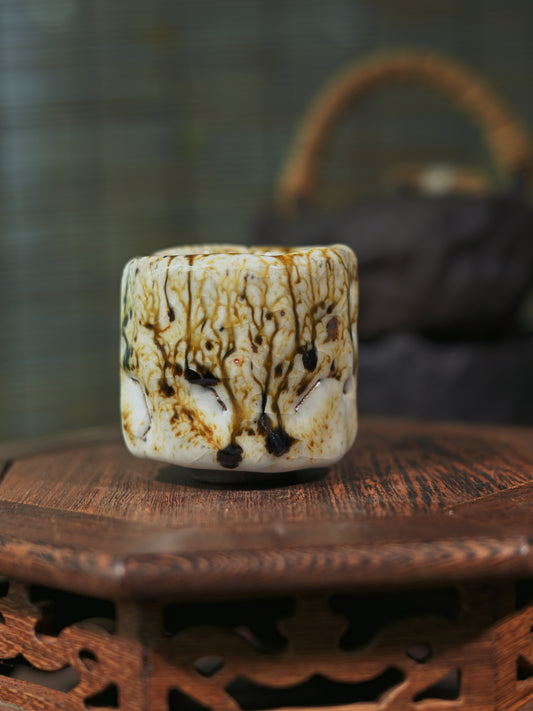 Close-up of the "Ashes Bloom" effect on a handmade Shino tea cup, showcasing natural mineral textures.
