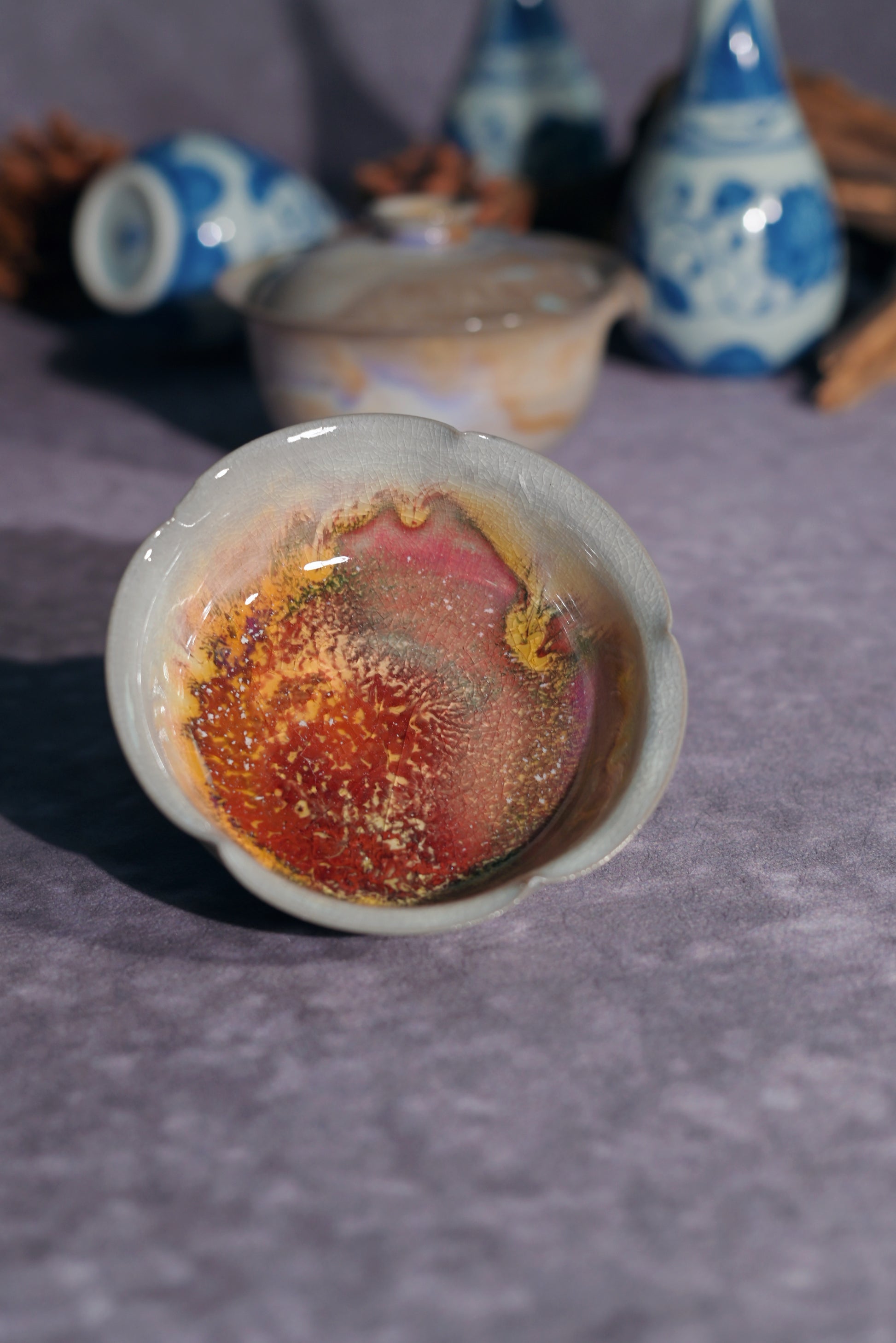 Exquisite lobed "flower-mouth" tasting cup with a shimmering lavender and gold wood-fired glaze.