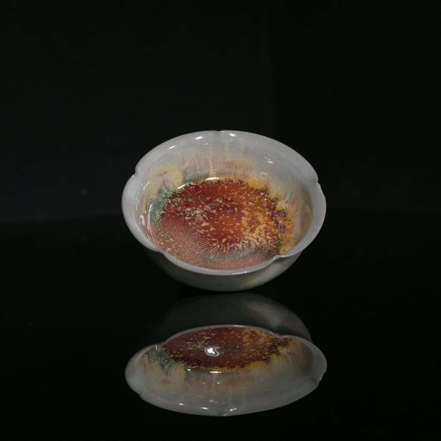 Hand-formed flower-petal tasting cup showcasing delicate wood-fired crackle glaze.