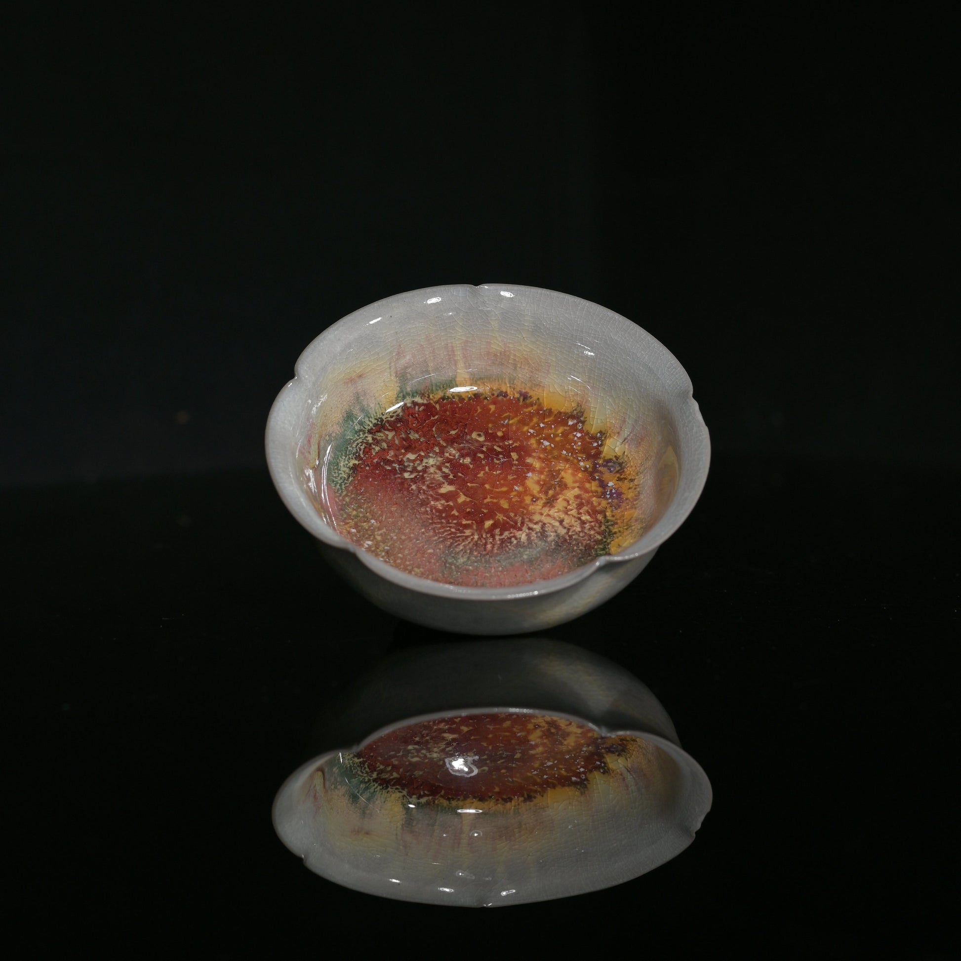 Hand-formed flower-petal tasting cup showcasing delicate wood-fired crackle glaze.