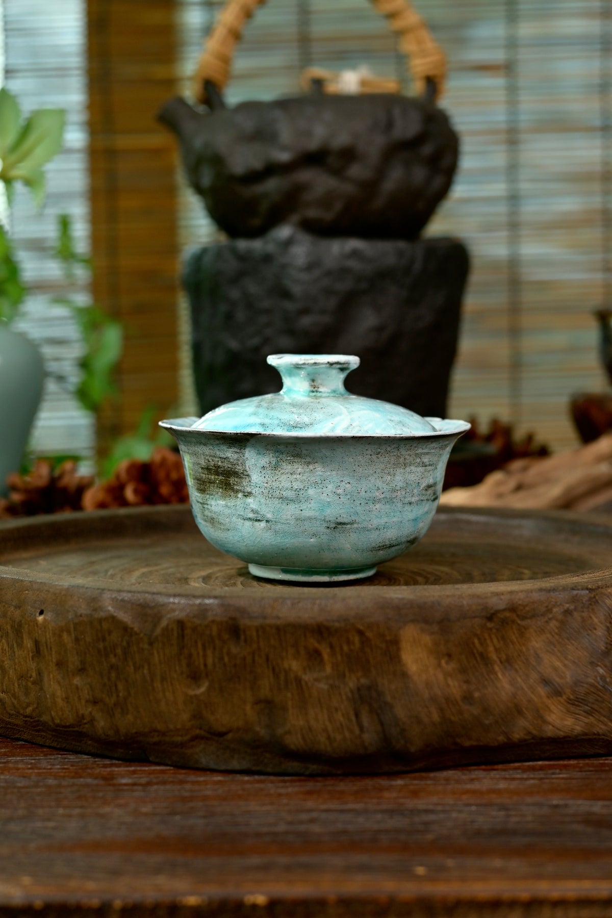 Handmade wood-fired soda kiln blue tea vessel 100ml displaying raw clay bottom and glaze contrast