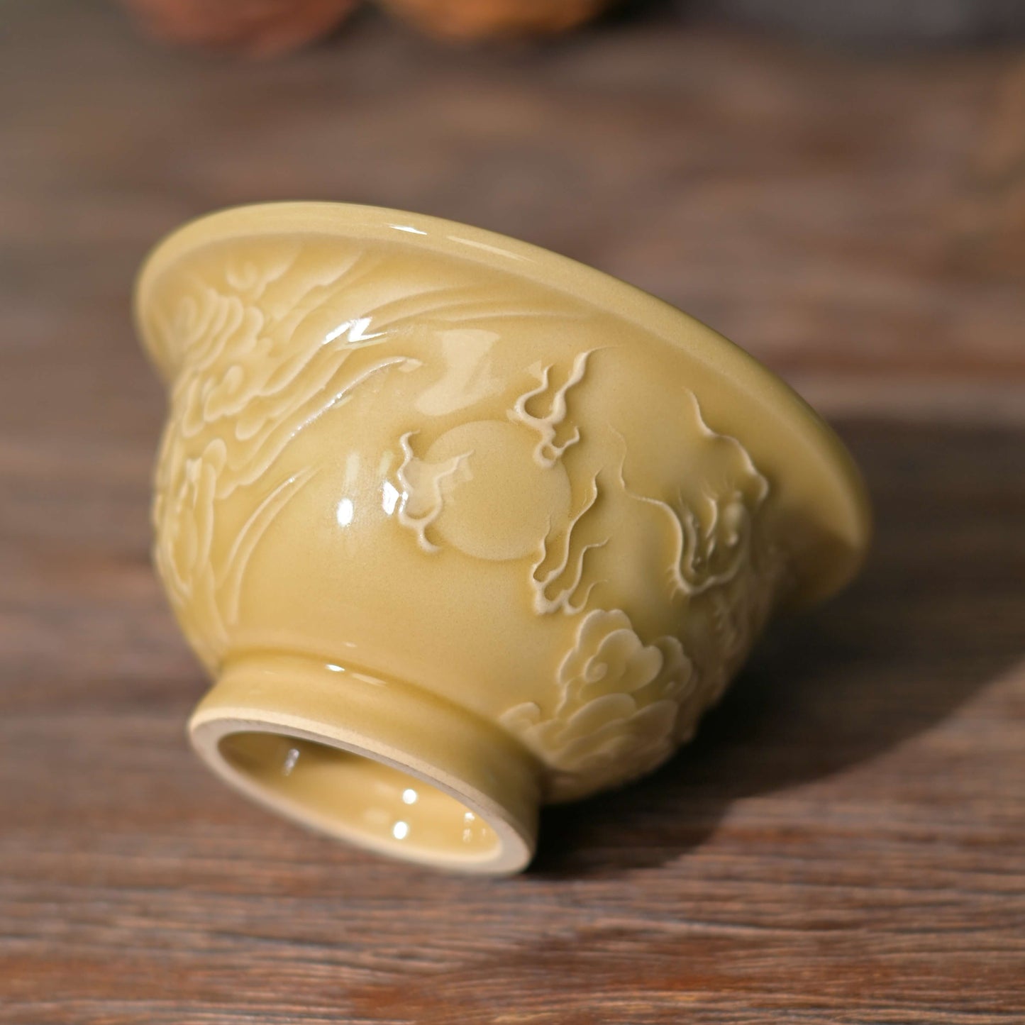 Studio shot of a rare Golden Glaze Longquan Celadon Kung Fu teacup with auspicious dragon motif.