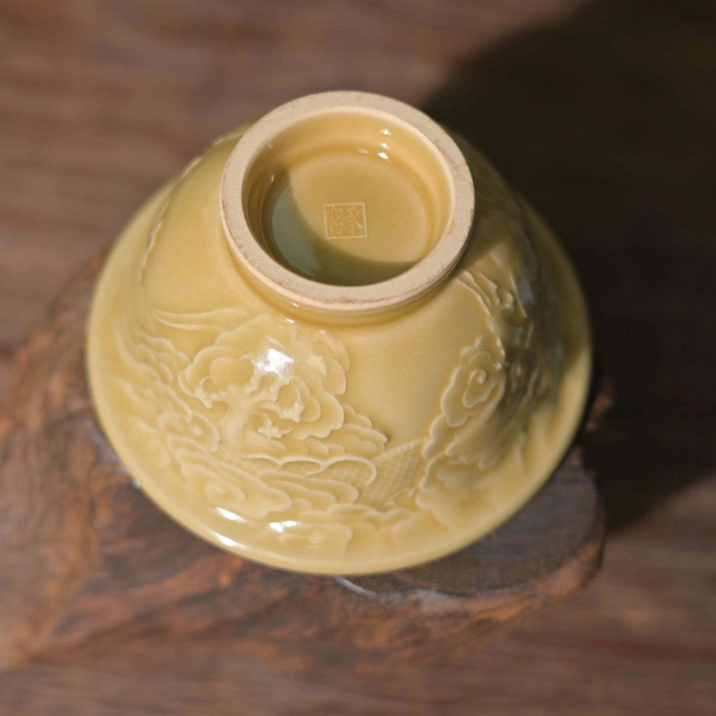 Detailed view of the intricate hand-carved dragon scales on the Imperial Longquan Celadon Golden Glaze teacup.