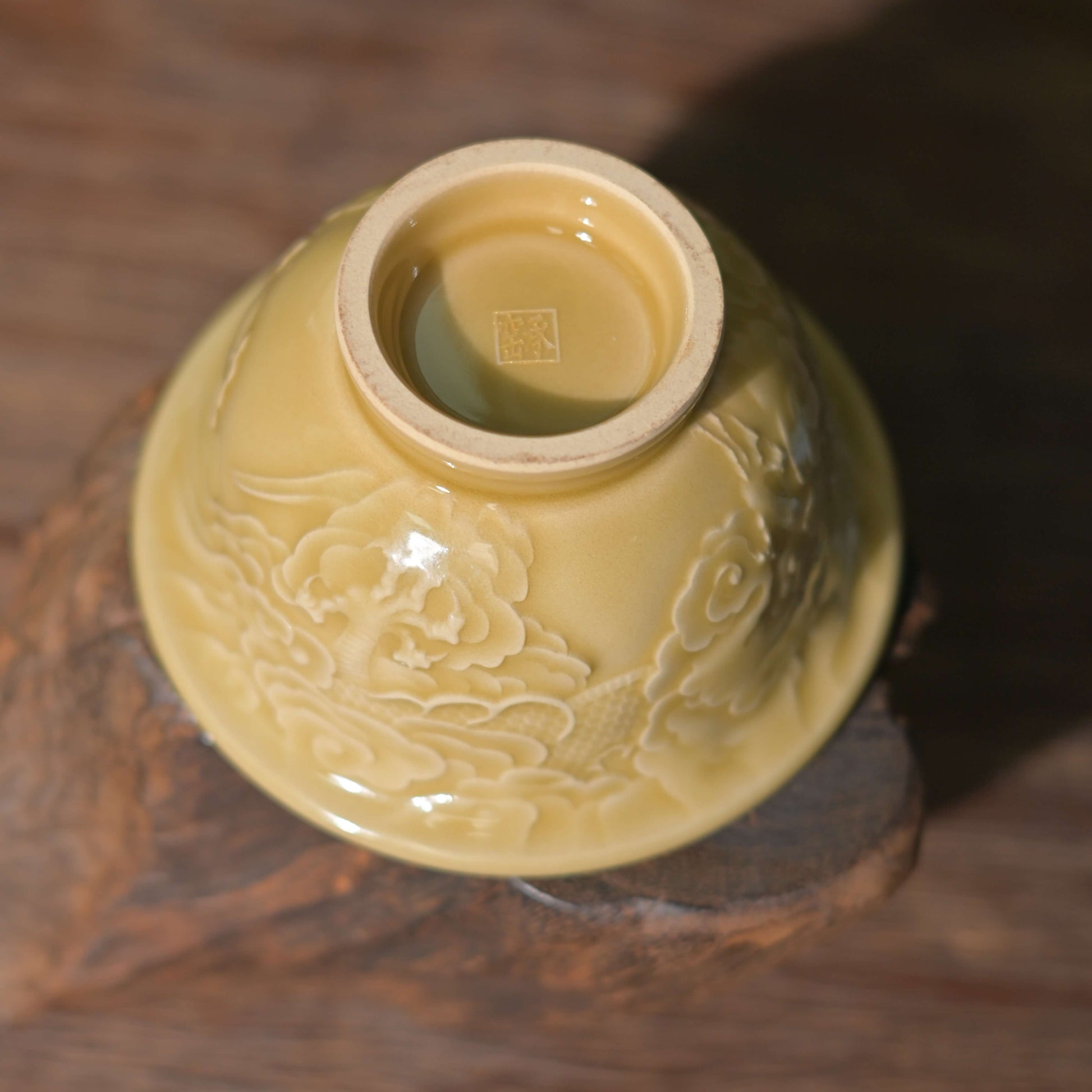 Detailed view of the intricate hand-carved dragon scales on the Imperial Longquan Celadon Golden Glaze teacup.