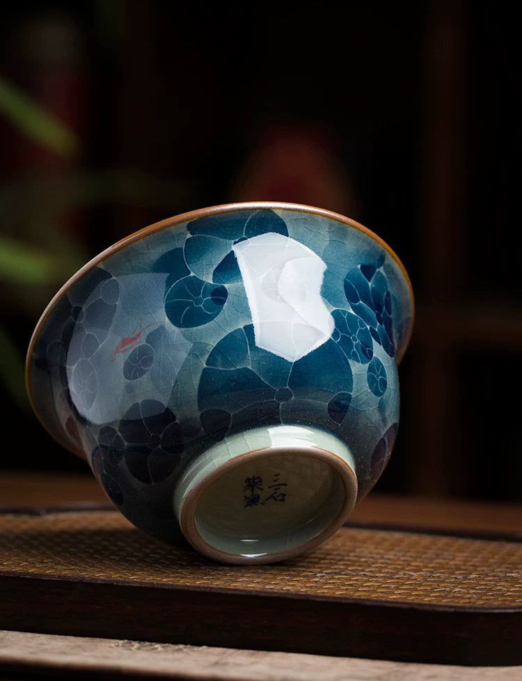 Underglaze painted porcelain tea bowl featuring vibrant blue and red floral accents.