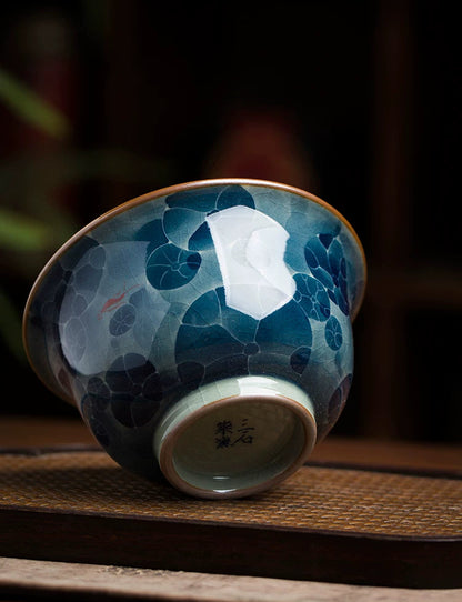 Underglaze painted porcelain tea bowl featuring vibrant blue and red floral accents.