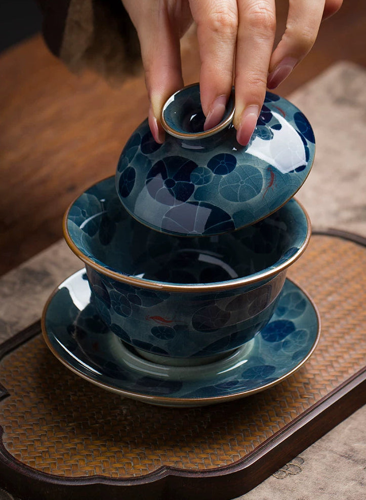 Close-up of hand-painted cobalt blue lotus flowers on a white Jingdezhen Kaolin porcelain gaiwan.