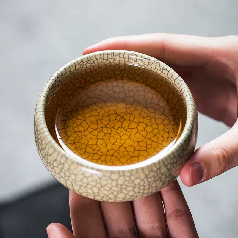 Close-up of intricate double crackle pattern (gold and dark lines) on a Ge Kiln porcelain tea vessel