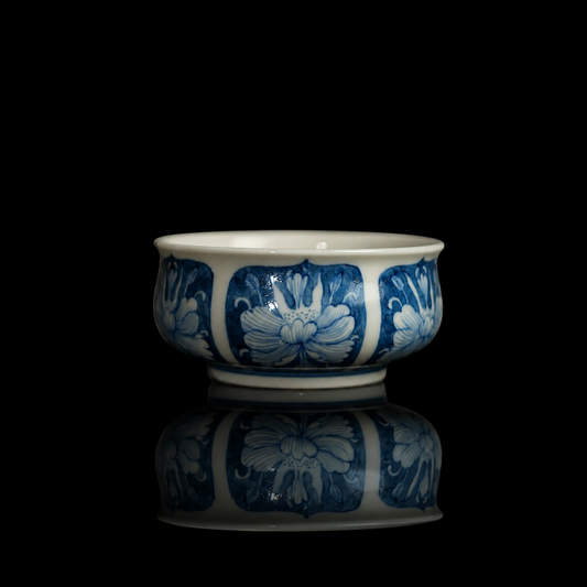 Antique-style blue-and-white porcelain teacup with hand-painted peony floral panels.