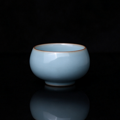 Ru Ware sky-blue glazed raw ore Arhat teacup 80ml resting on brown woven tea mat