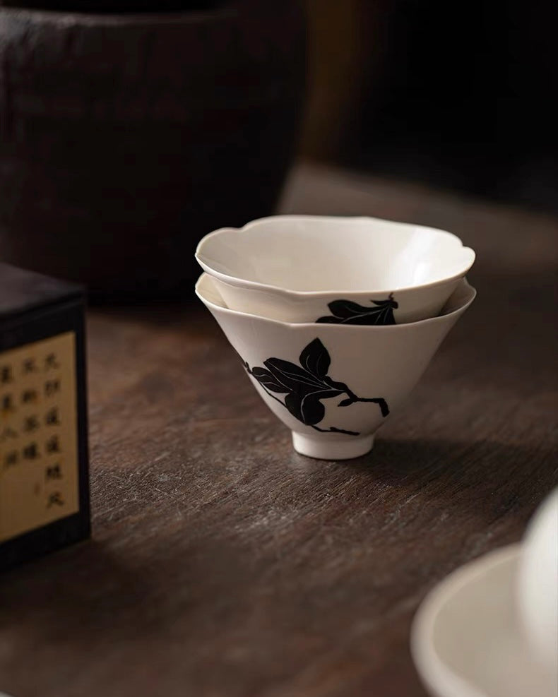 Contemporary tea ware with magnolia decoration, exhibiting crystalline ash glaze texture under light